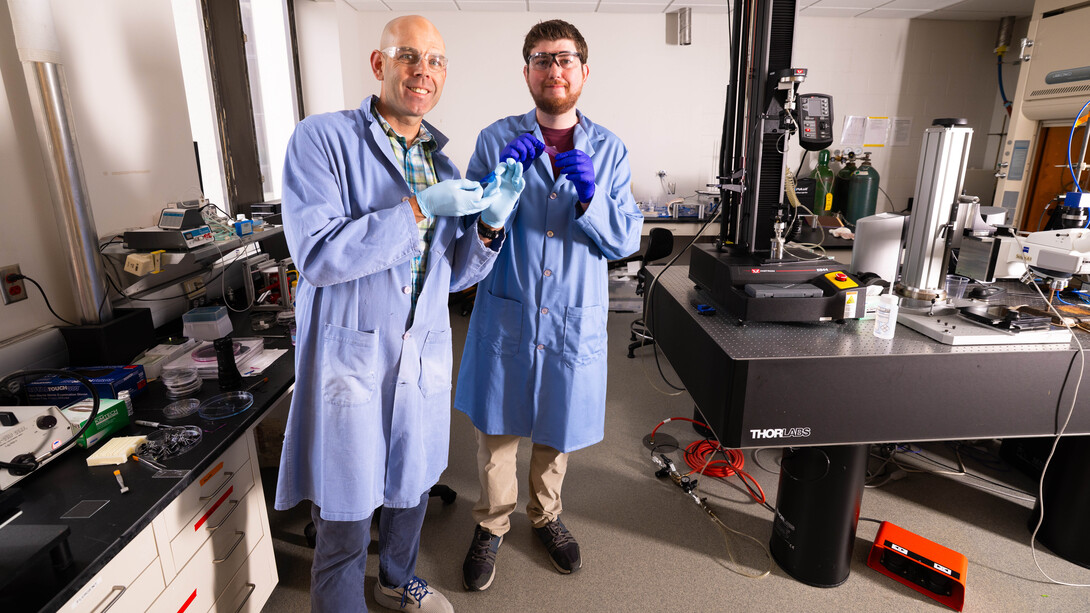 Stephen Morin, associate professor of chemistry, and Brennan Watts, a fourth-year doctoral student in chemistry, hold two colorful hydrogel skins that can act similarly to the color-changing skin of cephalopods such as octopi and cuttlefish.